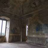Una scritta tracciata con una bomboletta spray blu in particolare deturpa una parte di muro che un tempo ospitava un dipinto